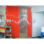 Porte à lanières transparentes et orange vif pour séparer des zones de stockage de zones de vente.